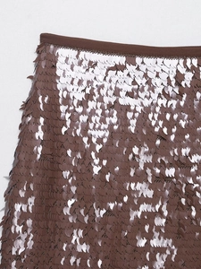 Détail de mini-jupe à paillettes marron bronze avec broderies denses et bordure de taille