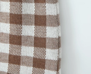 Macro shot showing detail of brown and white checkered pattern knit fabric texture