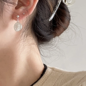 Macro detail of 925 sterling silver coin earrings featuring Elizabeth II profile relief