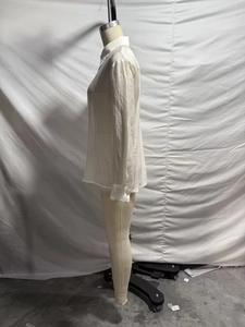 Detailed view of the white long-sleeved shirt showing its unique crinkled fabric texture