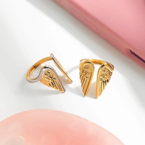 Detailed view of 18K gold-plated stainless steel angel wing rings with feather texture