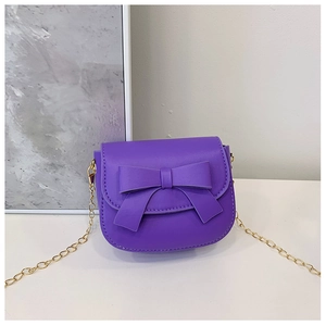 Detail of purple mini crossbody bag with large bow decoration and gold chain strap