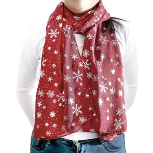 Détail d'une écharpe d'hiver rouge foncé avec flocons de neige argentés en tissu de coton
