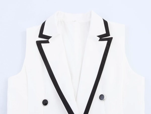 Détail du gilet blanc sans manches avec revers noir contrasté et boutons à double boutonnage