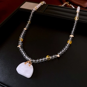 Detail of glass beaded necklace with large translucent white gemstone pendant