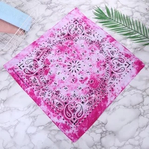 Close-up of pink paisley tie-dye cotton bandana on a white marble background