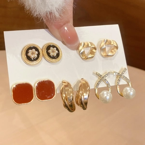 Detail view of 5-pair pearl and enamel earring set with gold accents on display card