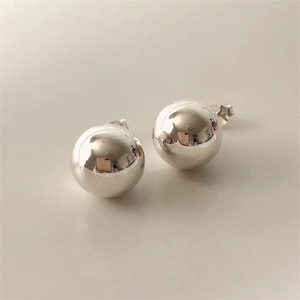 Macro shot of minimalist S925 sterling silver ball earrings with mirror polish finish