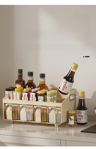 Detail of cream-colored kitchen spice rack showing top shelf and clear storage jars