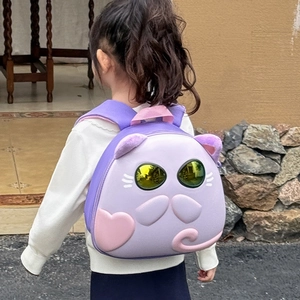 Toddler backpack with purple 3D cat design and yellow goggles on a young girl outdoors