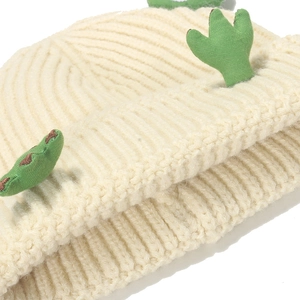 Detailed close-up of thick ribbed knit fabric and cute green cartoon frog-eye accents