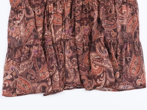 Close-up of brown paisley print fabric with ruffled hem and lightweight chiffon texture