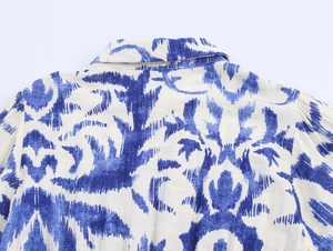 Close-up back detail of long sleeve shirt dress with blue and white ikat print pattern