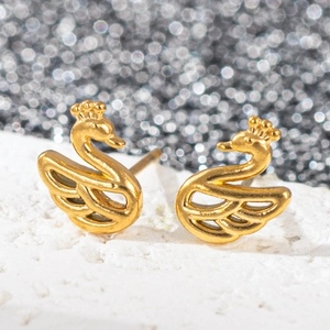 Vue macro de boucles d'oreilles cygne en acier inoxydable doré 18k sur fond scintillant