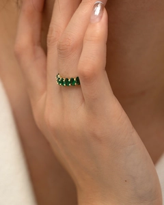 Detail of gold-plated ring featuring an oval green zircon pavé setting on a model finger
