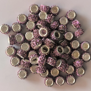 Macro shot of purple rhinestone-encrusted pave beads with silver metal core for DIY jewelry