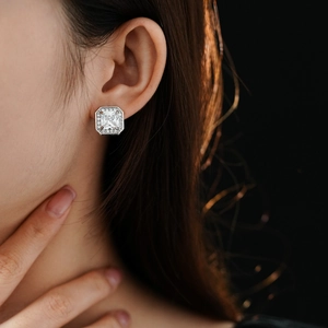 Gros plan sur un modèle portant des boucles d'oreilles carrées en zircon argenté