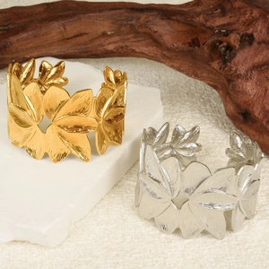 Detailansicht der 18K gold- und silbernen Blütenarmbänder auf einem Steinsockel