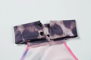 Close-up of halter neck collar with black bead buttons and abstract leopard print