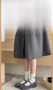 Close-up of white mid-calf socks with bow embroidery paired with grey skirt and Mary Janes