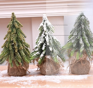 Three mini flocked Christmas trees with burlap bases for rustic tabletop festive decor