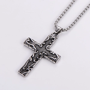 Macro view of vintage punk stainless steel cross pendant with detailed relief carving