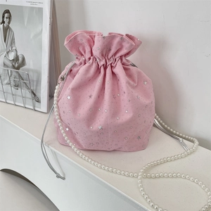 Pink drawstring bucket bag featuring silver stars and elegant pearl beaded strap detail