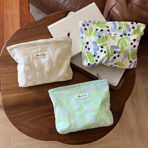 Detailed macro view of textured fabric makeup bags with floral patterns and zipper
