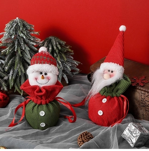 Close-up of knitted Christmas gift bags with Santa and Snowman drawstring details