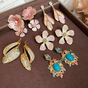 Close-up of assorted heart and flower earrings with enamel finish on a velvet tray
