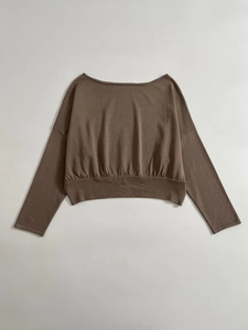 Détail du pull en maille marron avec ourlet large côtelé et texture décontractée