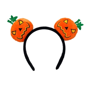 Close-up of plush orange pumpkin headbands with embroidered faces and green felt leaves