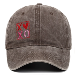 Dettaglio del ricamo cuore rosso e XOXO sul tessuto in cotone lavato del cappellino