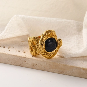 Detailed view of snake texture 18k gold steel ring featuring a dark blue gemstone