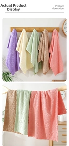 Detailed view of soft coral fleece towels with embossed bear pattern and wavy edges