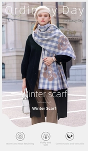 Detail of blue and white checkered winter scarf with brown camellia floral print and tassels