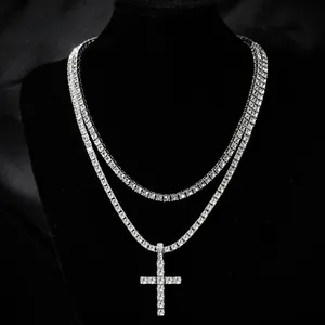 Close-up of hip hop silver finish cross pendant and tennis chain necklace with clear crystals