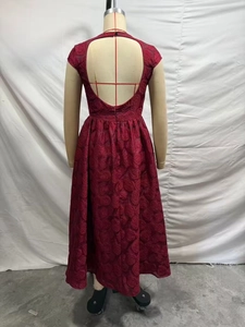 Vue détaillée du dos de la robe rouge foncé avec texture florale 3D et élégant dos nu