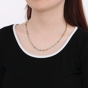 Détail du collier à cœurs reliés en or et argent porté par un mannequin en gros plan