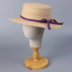 Flat top raffia sun hat with purple ribbon bow on a model head for summer sun protection