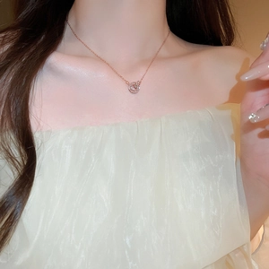 Detail of rose gold butterfly pendant necklace with zircon pavé on a female model