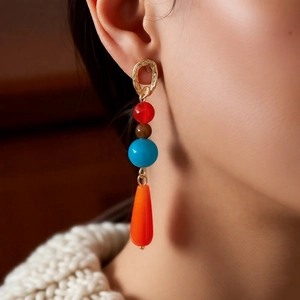Close-up of ethnic style beaded drop earrings with colorful agate stones on model