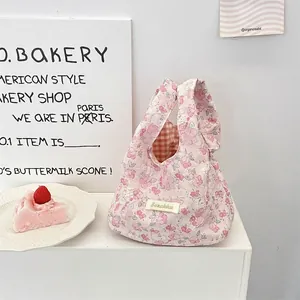 Dettaglio borsa trapuntata con stampa floreale rosa e fodera a quadretti arancioni