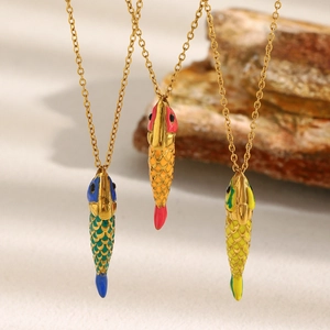 Three 18K gold plated fish necklaces with colorful enamel pendants on beige fabric
