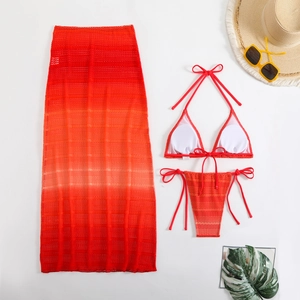 Vista piatta del set bikini sfumato rosso con gonna da spiaggia e accessori estivi