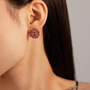 Close-up of elegant flower stud earrings with pink zircon on model ear