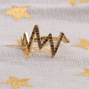 Minimalist heartbeat gold ring with multicolor zircon stones on star pattern fabric