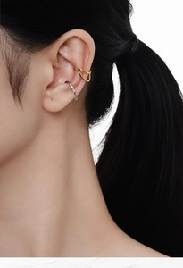 Detail of gold minimalist ear cuff and silver crystal cuff on a model's ear
