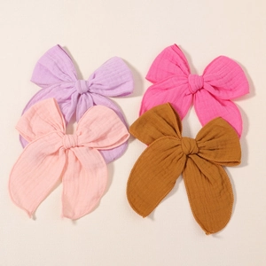 Set of four colorful linen bow hair clips in purple, pink, and yellow for women