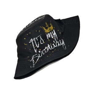 Detailed view of the 'IT'S MY Birthday' print with a yellow crown on a black bucket hat